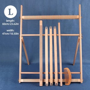 May include: A wooden weaving loom with a length of 23.62 inches (60 cm) and a width of 18.50 inches (47 cm). The loom includes a comb, a ruler, and several weaving tools. The background is a solid blue.