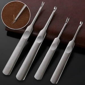 Puede incluir: Un juego de cuatro descosedores de metal plateado con mangos planos de acabado cepillado y una hendidura circular para el pulgar. Cada herramienta tiene un cuello delgado y una punta afilada en forma de horquilla, mostrada en un detalle circular.