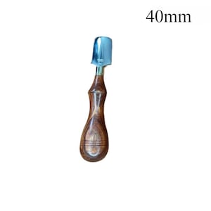 May include: A wood-handled leathercraft tool with a 40mm (1.57 inch) wide, curved, silver-colored blade. The handle is a dark brown, polished wood with a contoured shape for grip.