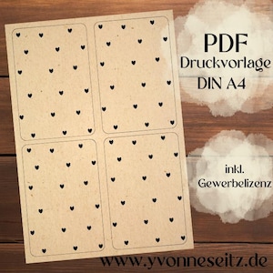May include: A sheet of kraft paper with four rectangular label templates, each adorned with small black heart shapes. The text "PDF Druckvorlage DIN A4" and "inkl. Gewerbelizenz" are visible, along with a website address.