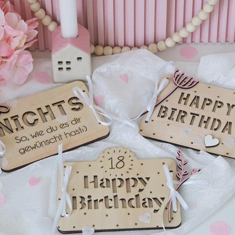 May include: Three wooden signs with pink and white accents. The signs say "NICHTS So, wie du es dir gew&uuml;nscht hast:", "Happy Birthday" and "18 Happy Birthday".