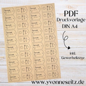 Könnte beinhalten: Eine druckbare Seite mit 24 Geschenkanhängern mit braunem Hintergrund und schwarzem Text. Die Anhänger zeigen ein Hufeisen und den Text "Viel Glück" und "Glückspilz".