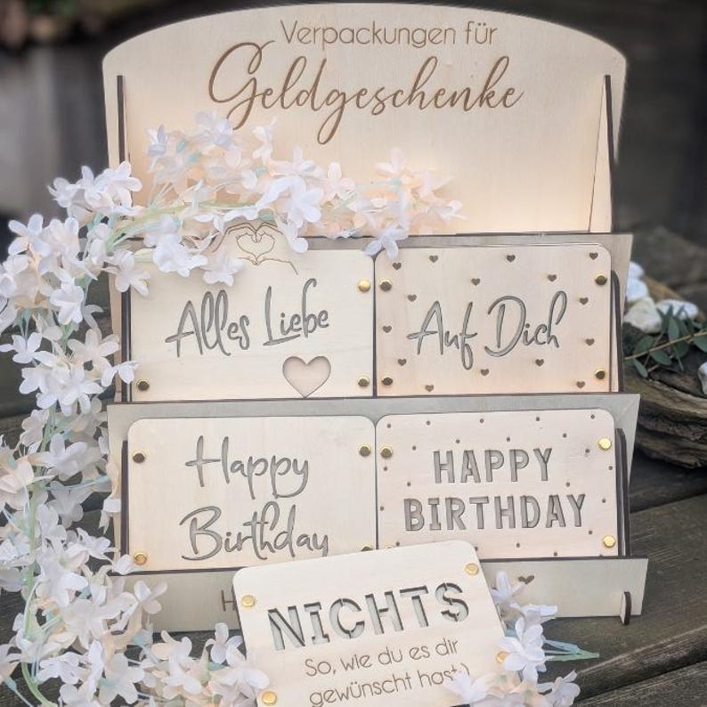 May include: Wooden display stand with four cards featuring different messages: "Alles Liebe", "Auf Dich", "Happy Birthday", and "NICHTS So, wie du es dir gew&uuml;nscht host".