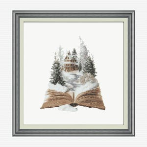 Peut inclure: Une broderie au point de croix encadrée représentant un livre ouvert d'où émerge un paysage hivernal. La scène montre une petite maison entourée de sapins enneigés et d'un chemin sinueux, le tout dans des tons de brun, blanc et vert.