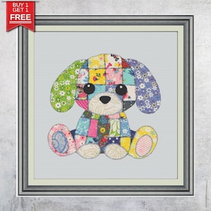 May include: A framed cross-stitch of a patchwork dog with large black eyes, a black nose, and floppy ears. The dog is made of colorful fabric squares in various patterns and colors, including pink, blue, yellow, and green. The frame is silver.