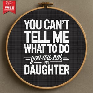 May include: A black cross-stitch hoop with the text "YOU CAN'T TELL ME WHAT TO DO - you are not - MY DAUGHTER" in white. The hoop is framed in a wooden ring. A red and white "BUY 1 GET 1 FREE" tag is in the upper left corner.