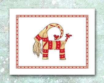 May include: A festive Christmas card featuring a straw goat, a traditional Swedish Yule Goat. The goat is adorned with red ribbons and a red and white striped scarf. The card has a red border and is set against a wintery background.
