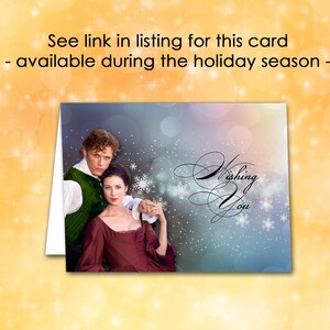 May include: Greeting card featuring a couple in period attire, with the words "Wishing You" in elegant script. The background has a soft, blurred effect with snowflakes. The card is available during the holiday season.