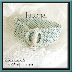 以下が含まれることがあります： 白とターコイズのビーズで作られたブレスレットで、白いボタン留め具が付いています。ブレスレットは白いレースの背景の上に置かれています。画像の上部には「チュートリアル」というテキストが、下部には「Wrapped to Perfection」というテキストがあります。