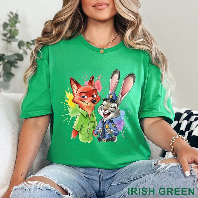 May include: Irish green t-shirt featuring a colorful graphic of Nick Wilde and Judy Hopps from Zootopia. The design includes vibrant paint splatters. The text "IRISH GREEN" is at the bottom of the image.