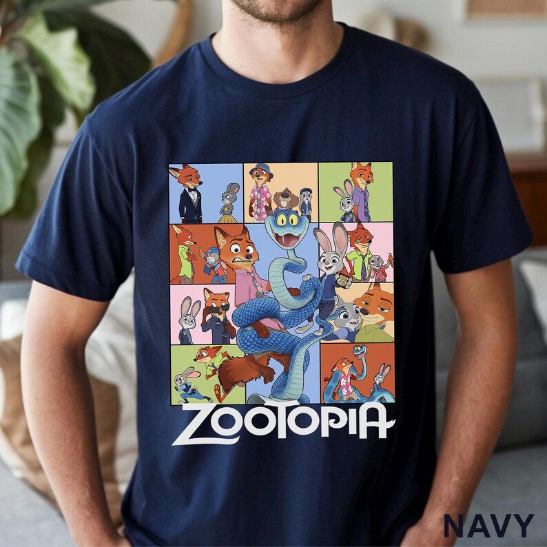 Peut inclure: T-shirt bleu marine avec un collage color&eacute; de personnages du film d'animation "Zootopie". Le motif comprend divers personnages d'animaux et le mot "Zootopie" en lettres blanches. Le t-shirt est en mati&egrave;re souple.