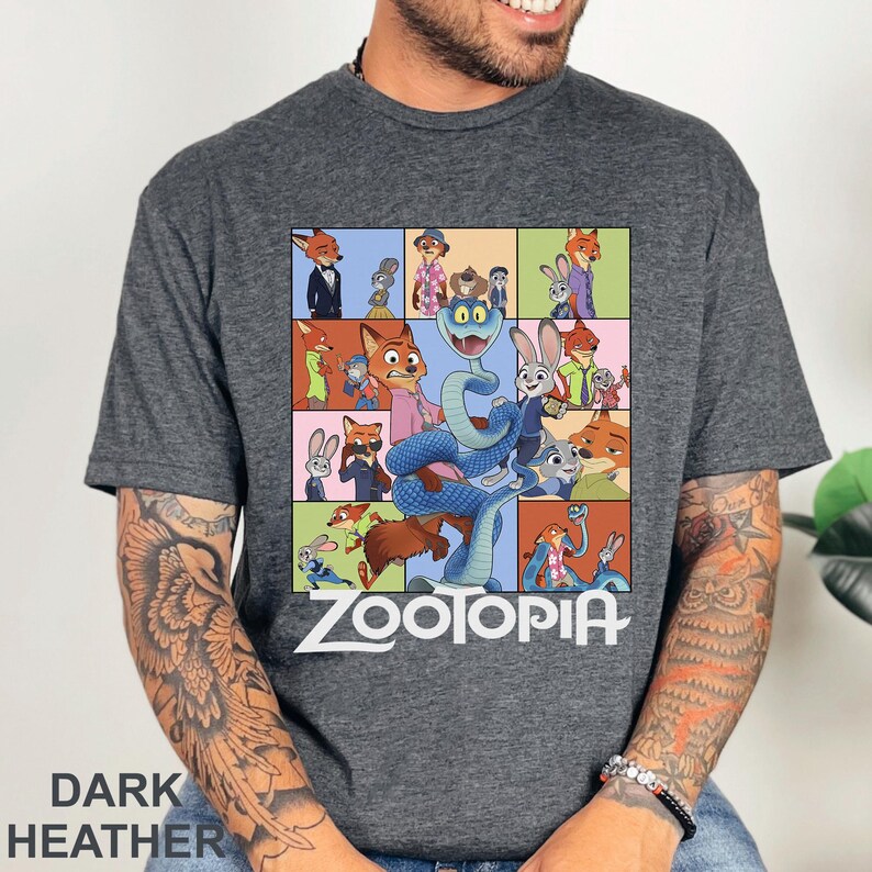 Peut inclure: T-shirt gris chin&eacute; fonc&eacute; avec un graphisme color&eacute; des personnages du film d'animation Zootopie. Le motif comprend une grille d'images avec le mot "Zootopia" en blanc. Le t-shirt est fait d'une mati&egrave;re douce.