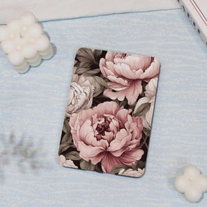 May include: A pink and white floral pattern on a black background. The pattern features large peonies and smaller flowers. The design is perfect for a phone case or laptop skin.