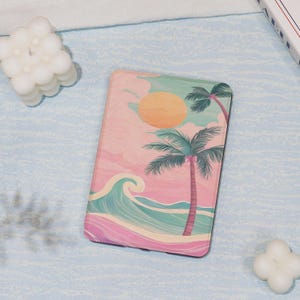 May include: A rectangular case featuring a tropical beach scene. The design includes a large orange sun, palm trees, and ocean waves in shades of pink, teal, and green. The case has a black border.