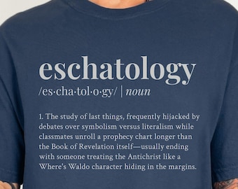 Op de afbeelding: Marineblauw T-shirt met het woord "eschatology" in lichtgrijze letters, samen met de uitspraak en definitie. De definitie beschrijft de studie van de laatste dingen. Het shirt is een casual kledingstuk.