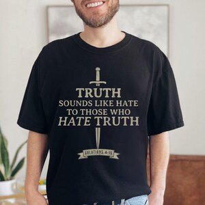May include: Black t-shirt with a sword graphic and the text "TRUTH sounds like hate to those who hate truth" and "Galatians 4:16". The shirt is made of a soft material.