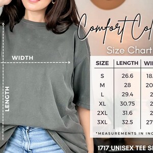 May include: A gray unisex tee shirt with a size chart showing measurements in inches. The chart lists sizes S to 3XL, with lengths from 26.6 to 32.5 inches and widths from 18.25 to 27.75 inches. The shirt is labeled "1717 UNISEX TEE SHIRT."