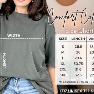 May include: A gray unisex tee shirt with a size chart showing measurements in inches. The chart lists sizes S through 3XL, with lengths from 26.6 to 32.5 inches and widths from 18.25 to 27.75 inches. The shirt is labeled "1717 UNISEX TEE SHIRT."