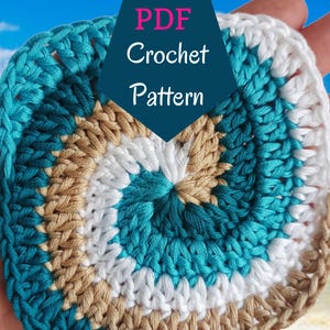 Może przedstawiać: Wzór na szydełkowy, kolorowy, okrągły podkładka lub podkładka pod talerz. Wzór wykonany jest z turkusowej, białej i brązowej przędzy w spiralnym wzorze. Obraz zawiera tekst "PDF Crochet Pattern".