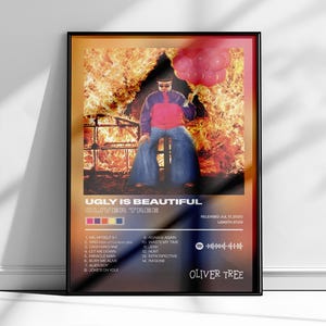 May include: A rectangular poster featuring the album cover for Ugly Is Beautiful by Oliver Tree. The image shows a person in a pink and blue jacket and blue jeans sitting on a stool in front of flames, holding pink balloons. Includes tracklist.