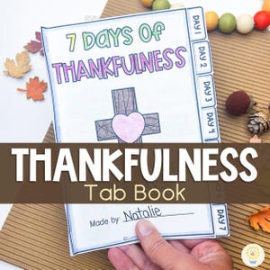 May include: A tab book titled "7 Days of Thankfulness" with a cross and heart illustration. The cover features the text "7 Days of Thankfulness" in green and purple. The book is open, revealing tabs labeled "Day 1" through "Day 7". The text "Thankfulness Tab Book" is also visible.