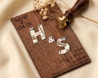 May include: A rectangular dark wood save the date card featuring iridescent mother-of-pearl inlay letters H and S, an ampersand, and engraved text including Harry & Selena, 09.14.26, Asheville, NC, and formal invitation to follow, with a wax seal stamp.