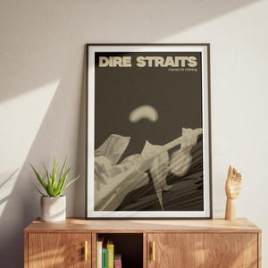 May include: A framed poster with a black and white image of a person playing a guitar. The poster has the text "Dire Straits" and "Money for Nothing" in white letters.