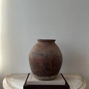 May include: A set of three ceramic mugs with a speckled, cream-colored glaze. Each mug features a different hand-painted floral design in shades of blue, green, and yellow. The mugs have a simple, rounded shape and a comfortable handle.