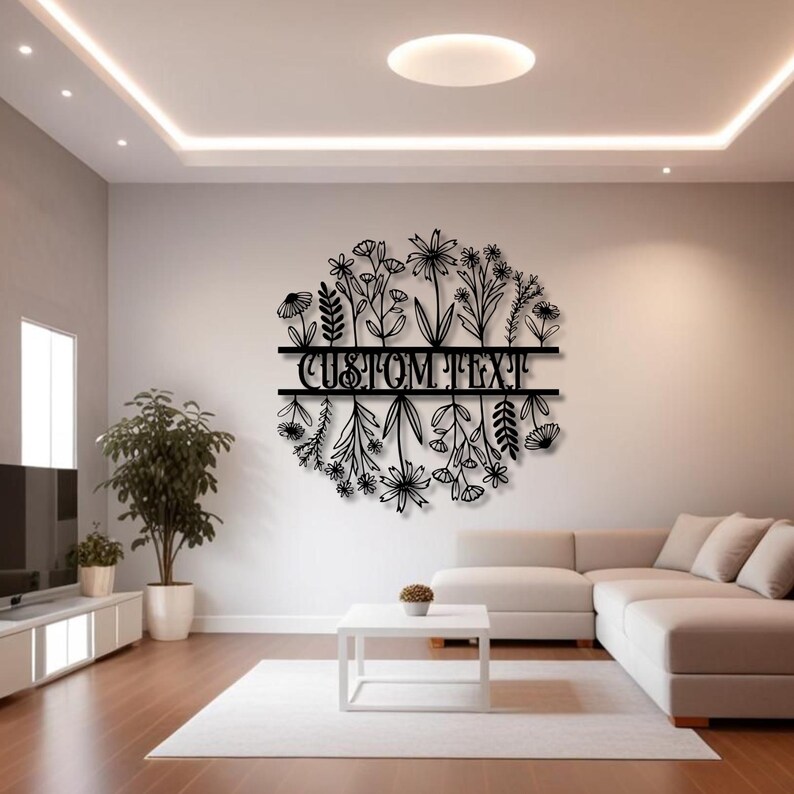 May include: A black metal floral wall art piece with the text "CUSTOM TEXT" in the center. The artwork features a circular design of various flowers and foliage, suitable for home decor.