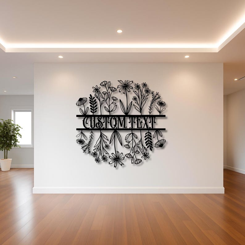 May include: Black metal floral wall art with the text "CUSTOM TEXT" in the center. The design features a circular arrangement of various flowers and foliage, suitable for home decor.