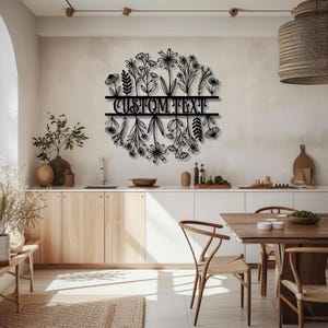 May include: Black metal floral wall art with the text "CUSTOM TEXT" in a kitchen setting. The art features a circular design of various flowers and foliage, adding a decorative touch to the space.