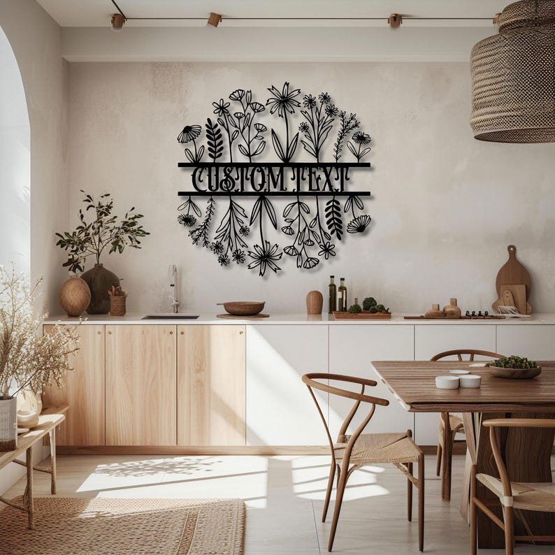 May include: Black metal floral wall art with the text "CUSTOM TEXT" in a kitchen setting. The art features a circular design of various flowers and foliage, adding a decorative touch to the space.