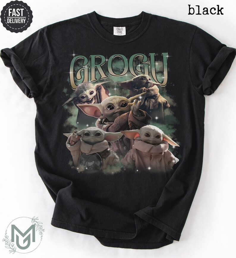 May include: A black short-sleeve t-shirt featuring a graphic print of multiple Grogu characters in various poses. The text GROGU is printed in a large, stylized font above the characters, surrounded by small star accents and a green mist effect.