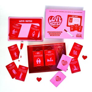 Pode incluir: Um conjunto de jogo Love Notes vermelho e rosa com um quadro branco de apagamento a seco, cartas e um marcador. O jogo inclui 104 prompts para deixar notas de amor para o seu parceiro.