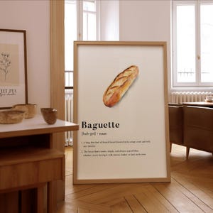 Könnte beinhalten: Eine Aquarell-Illustration einer Baguette, einem langen, dünnen Laib französischen Brotes, das für seine knusprige Kruste und sein weiches, luftiges Inneres bekannt ist. Der Text unter dem Bild lautet "Baguette [bah-get] - Substantiv 1. Ein langer, dünner Laib französischen Brotes, das für seine knusprige Kruste und sein weiches, luftiges Inneres bekannt ist. 2. Das Brot, das ikonisch, einfach und immer eine gute Idee ist, egal ob man es mit Käse, Butter oder einfach so isst."