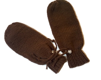 Könnte beinhalten: Ein Paar braune Strickhandschuhe mit Kordelzug. Die Handschuhe sind aus einem weichen, warmen Material gefertigt und perfekt, um Ihre Hände bei kaltem Wetter warm zu halten.