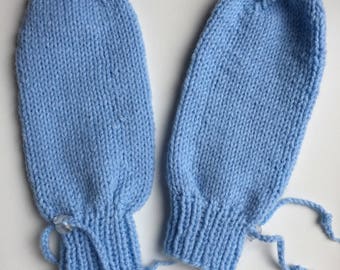 Könnte beinhalten: Ein Paar hellblaue Strickhandschuhe mit einem Kordelzug am Handgelenk.