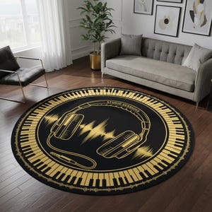 Peut inclure: Tapis rond noir avec un motif doré représentant un casque audio, des ondes sonores et des touches de piano. Le texte "STUDIO SESSIONS" est également inclus. Le tapis est posé sur un parquet sombre.