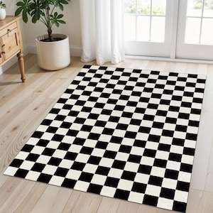 May include: Black and white checkered area rug with a square pattern. The rug is made of a soft, plush material.