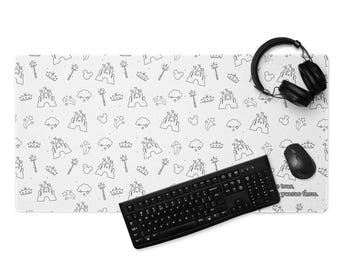 May include: White desk mat with a repeating pattern of castles, crowns, wands, and clouds in black outline. A black keyboard, mouse, and headphones are on the mat. The text "...be true, pursue them." is visible.