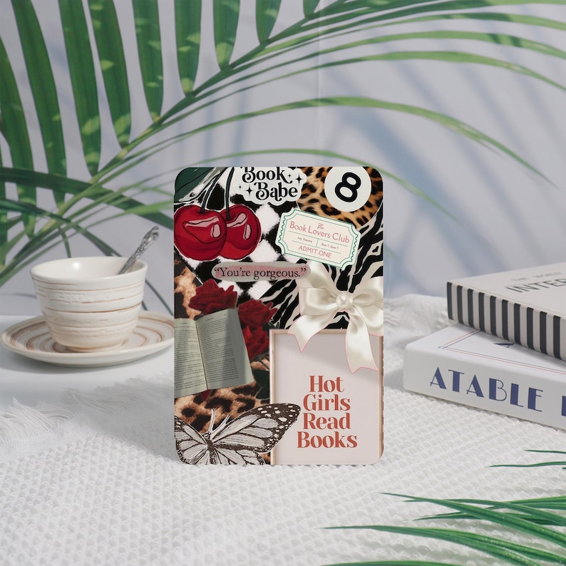 May include: A decorative rectangular card with a collage of images, including cherries, a butterfly, and leopard print. The card features the text "Book + Babe," "Hot Girls Read Books," and "You're gorgeous."