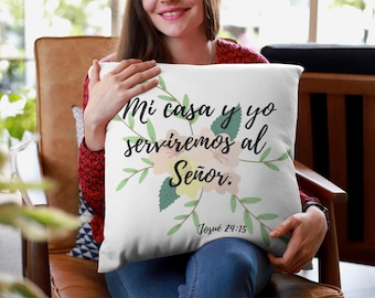 以下が含まれることがあります： 花柄の白いクッションで、"Mi casa y yo serviremos al Señor. Josué 24:15"というテキストが書かれています