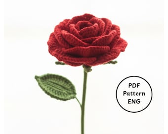 Könnte beinhalten: Eine handgefertigte rote Häkelrose mit grünem Stiel und Blatt. Die Rose steht in voller Blüte und zeigt detaillierte Blütenblätter. Der Stiel wird von einer Hand gehalten. Eine kreisförmige Grafik mit "PDF Pattern ENG" befindet sich im Bild.