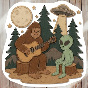 May include: A whimsical sticker featuring a brown Bigfoot playing a guitar for a green alien. The scene includes a UFO, moon, trees, and stars, all rendered in a stitched fabric style. The overall theme is a fun, extraterrestrial encounter.