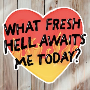 May include: A heart-shaped sticker with the text "WHAT FRESH HELL AWAITS ME TODAY?" in black. The heart is red with yellow flames at the bottom, set against a wood-grain background.