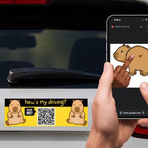 May include: A rectangular bumper sticker with a yellow background and black text that reads how's my driving? and SCAN ME!. The sticker features two cartoon capybaras and a central QR code. A smartphone displays a digital version of the design.