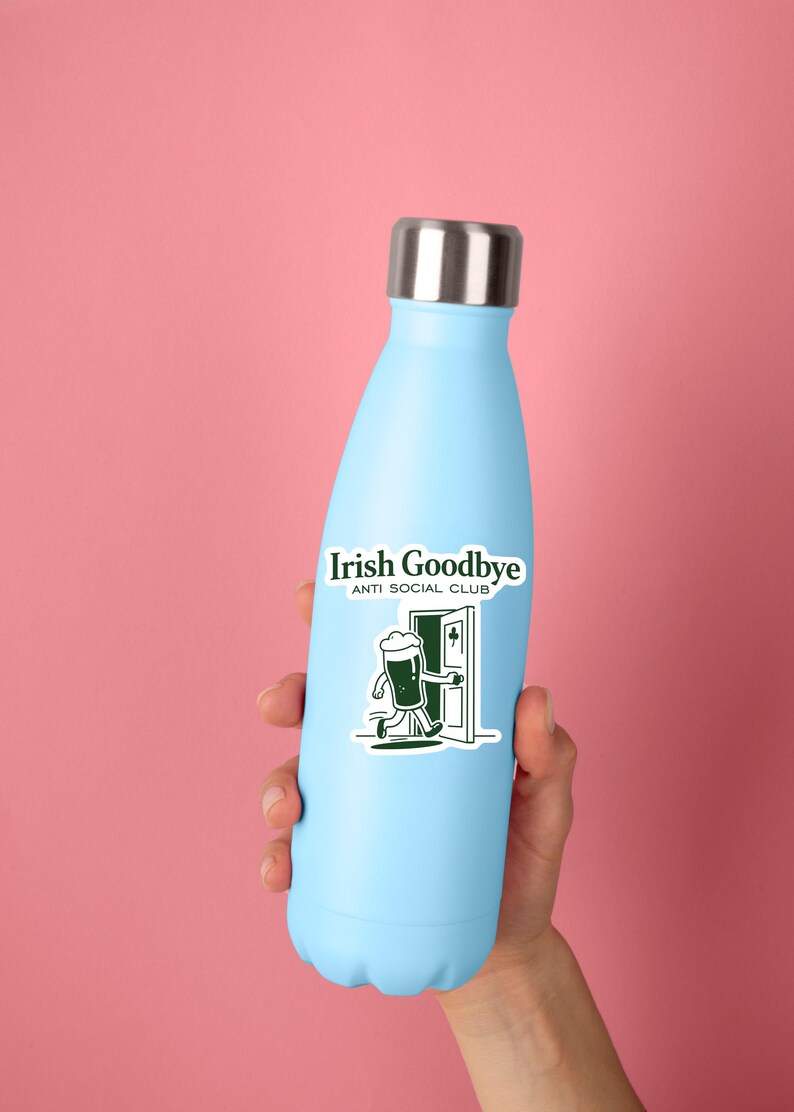Puede incluir: Una botella de agua aislada azul claro con tapa plateada. La botella tiene una pegatina que dice "Irish Goodbye ANTI SOCIAL CLUB" con un dibujo de un vaso de cerveza saliendo por una puerta. El fondo es rosa.