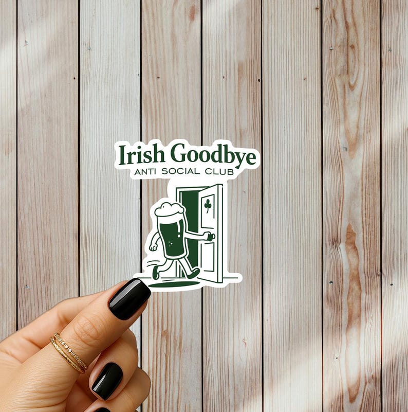 Puede incluir: Pegatina verde con el texto "Irish Goodbye ANTI SOCIAL CLUB". La pegatina presenta un vaso de cerveza de dibujos animados corriendo por una puerta. La pegatina est&aacute; sujeta por una mano con esmalte de u&ntilde;as negro y anillos dorados.