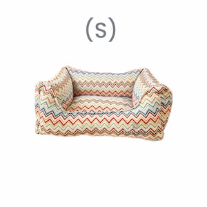 May include: A colorful chevron patterned dog bed with a raised edge and a soft, cushioned interior. (S)