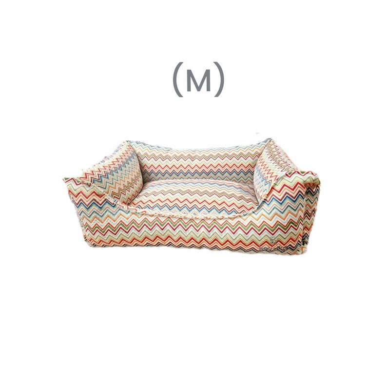 May include: A colorful chevron patterned dog bed with a raised edge and a removable cushion. The bed is labeled with the size (M).